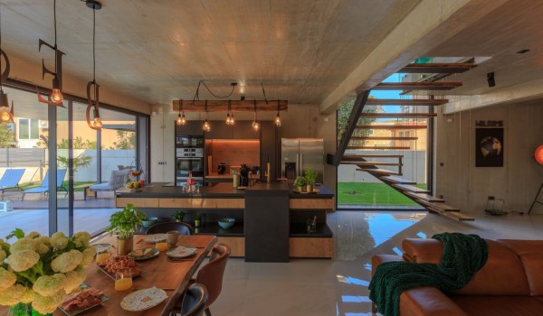 The interior of the luxury villa Krk Baska II with an open-plan wooden kitchen and a dining table