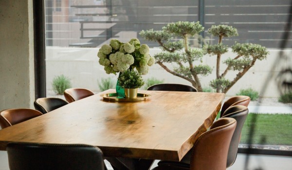 A wooden dining table set for eight people, decorated with fresh flowers in a modern villa in Baška on the island of Krk