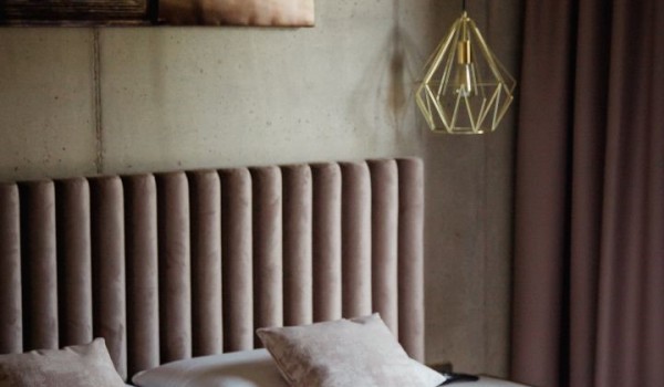 A room with a double bed and furnished beige bedding in the modern villa Krk Baska II in Baška on the island of Krk