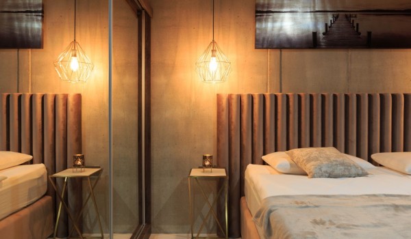 A room decorated in brown tones with a double bed and furnished beige bedding in a villa for rent on the island of Krk