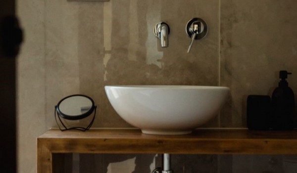 Bathroom of luxury villa Krk Baska II with wooden furniture, sink and mirror.