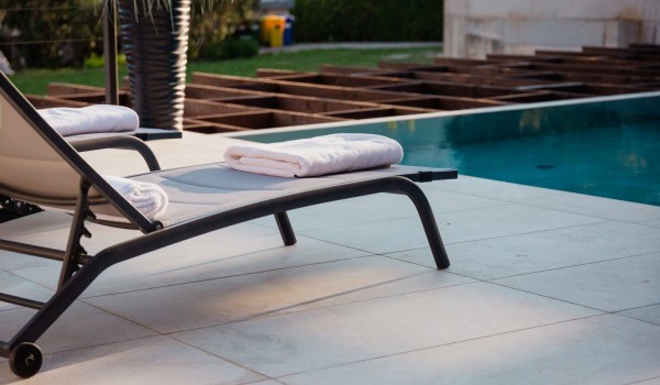 Sunbeds located on the outdoor terrace next to the outdoor heated swimming pool of a luxury villa in Baška on the island of Krk