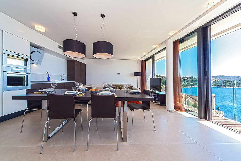 Dining table set for 6 people with chairs and a view of the sea in the luxury apartment Biseri Jadrana 1 in Primosten