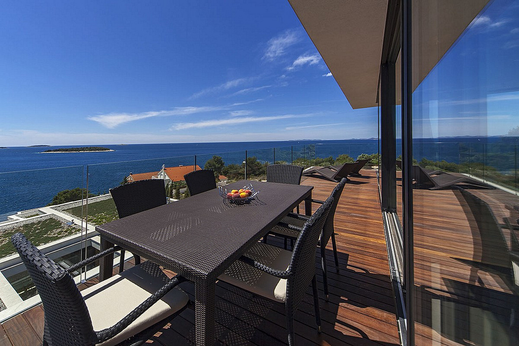 Stol i stolice na terasi s pogledom na more u luksuznom apartmanu Biseri Jadrana 5 u Primoštenu