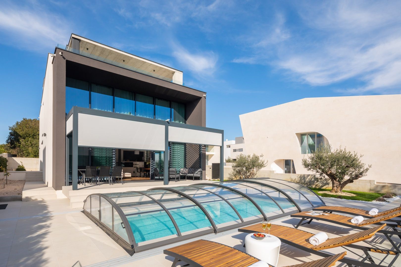 Prednji pogled na luksuznu vilu Idria Sea and View s privatnim grijanim i natkrivenim bazenom, sunčalištem s ležaljkama i terasom s elektroničkim pergola sustavom