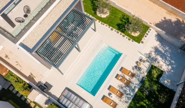 Upper perspective on the Luxury Villa Idria Sea and View with private heated pool, patio with loungers, olive trees, balcony with outdoor furniture, mobile grill and roofed terrace