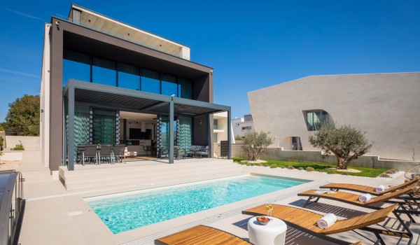 Patio with 4 loungers and a small table by the private heated pool in front of the Luxury Villa Idria Sea and View Petrcane
