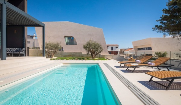 Pool view with loungers, seating area with a small table and olive trees in the background