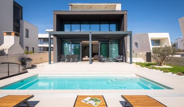 Front view of Luxury Villa Idria Sea and View with private heated hydro massage pool, patio with loungers and terrace with electronic pergola system