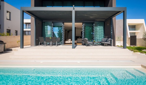 A view from the heated hydro massage pool on the front of the Villa Idria with the terrace and the glassed wall entrance to the living area