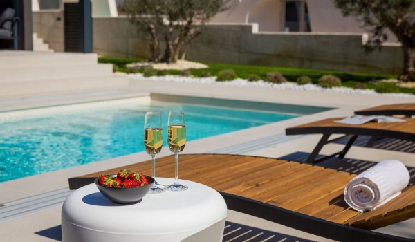 Leisure area with the sun loungers and a small table by the pool of Luxury Villa Idria Sea and View Petrcane