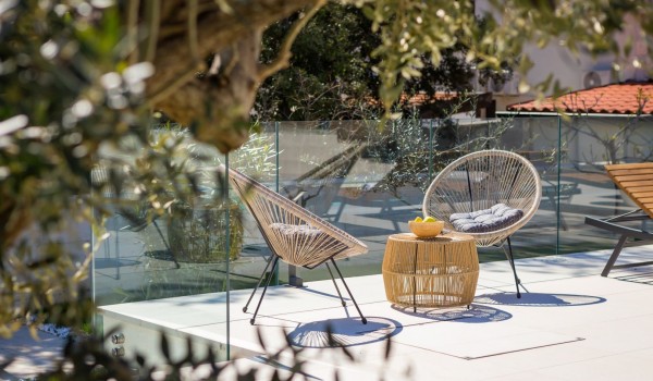 Lovely seating area by the transparent glass barriers surrounding paved patio in front of the Luxury Villa in Petrčane