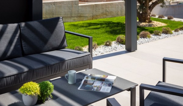 A detail of the seating area on the terrace with comfortable garden furniture and a coffee table in front of the Luxury Villa Idria Sea and View