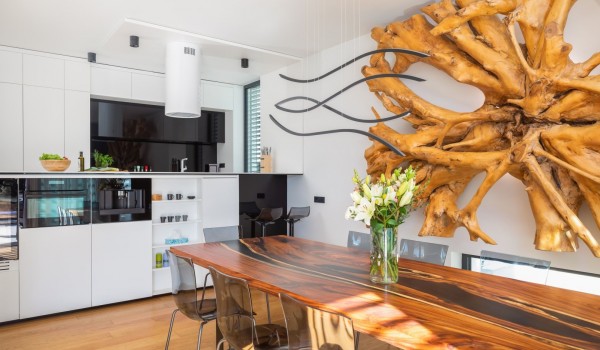 Open plan space of the kitchen and a dining area on the ground floor of Luxury Villa Idria Petrcane with a statement decoration on the wall and dining set for 8