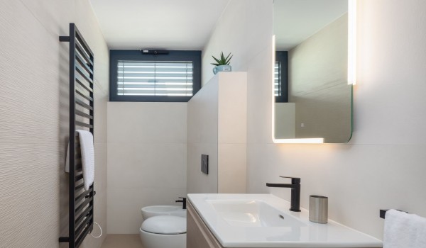 A Toilet located on the first floor with a toilet, a bidet, a sink and a mirror with inbuilt light