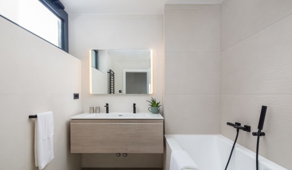 A view of bathtub and a sink with mirror of the bathroom on the first floor of the Villa