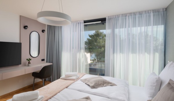 A bedroom on the first floor of Luxury Villa Sea and View Petrcane with air condition, LCD TV, king size bed and a splendid sea and greenery view through glass walls
