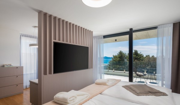 Modern decorated open plan master bedroom with LCD TV en suite bathroom, room dividers towards the spa section with a bathtub and a large sea view terrace of the Luxury Villa Sea and View Pet