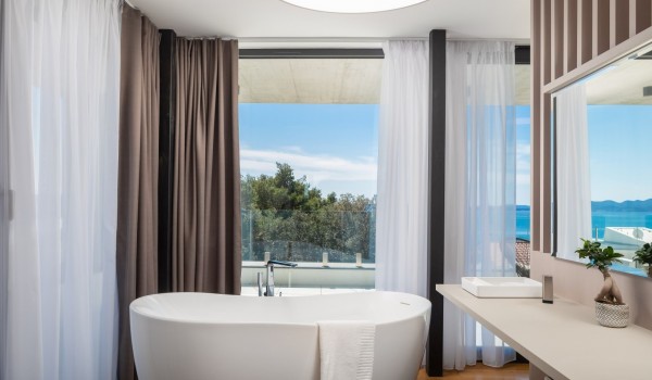 A SPA section of the master bedroom with en suite bathroom on the second floor, a sea view from the modern bathtub with the modern room dividers and glass wall exit for the spacious terrace