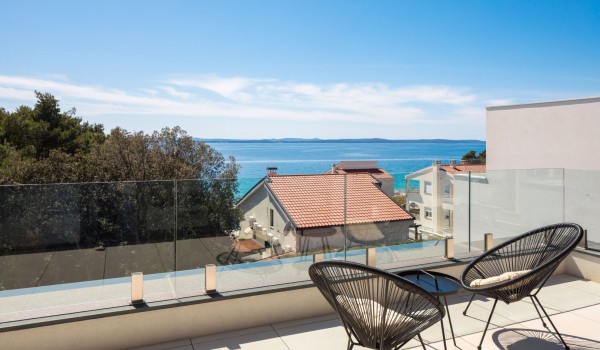 Sea view from the spacious roofed terrace of the master bedroom with a comfortable seating set of two chairs and a coffee table