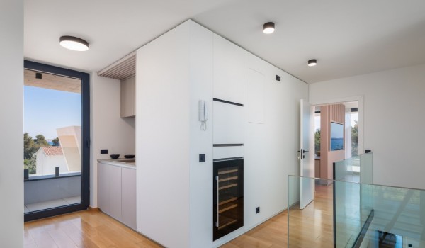 Second floor of Luxury Villa Idria Sea and View with a kitchenette, a wine fridge, exit on the balcony and a view on the bedroom entrance