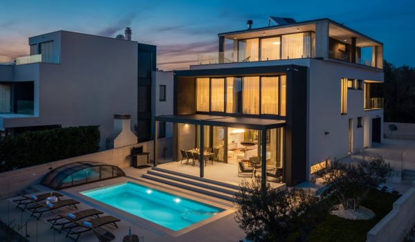 Night view on the property of Luxury Villa Sea and View Petrcane with sun loungers, patio and swimming pool in the front plan