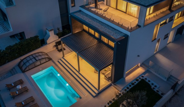 Aerial night vision perspective on the outdoor villa area, pool with the patio and sun loungers, main terrace and bedroom terrace with garden furniture