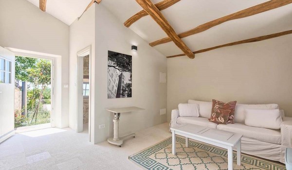 Minimalistic living room with a white sofa and access to the private yard of a luxury villa for vacation and rental in Istria