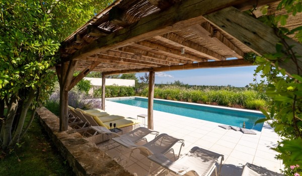 Roofed part of the terrace with sun loungers and a private pool on the tiled terrace of the luxury villa Deluxe Manor Baderna in Istria