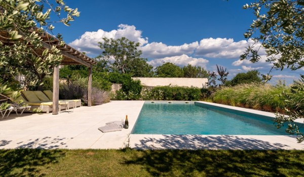 Fenced terrace with a private pool and sun loungers in the garden of the family vacation villa Deluxe Manor Baderna