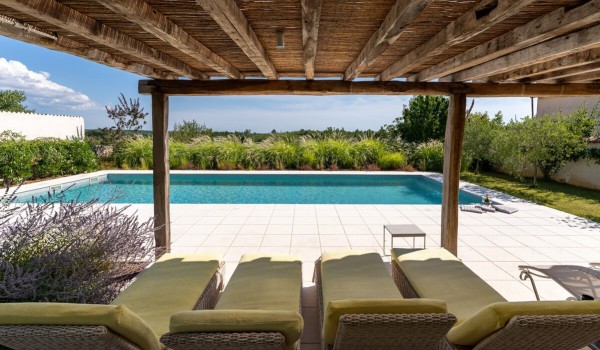 View from the roofed part of the terrace of the private pool surrounded by greenery from the landscaped garden