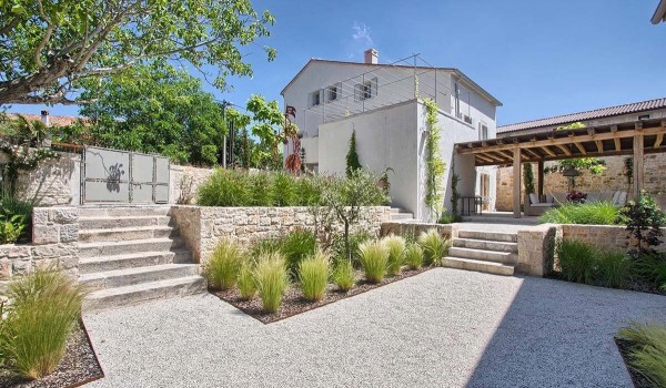 External stairs leading to the roofed terrace of the main house in the landscaped yard of a luxury villa for rent in Istria