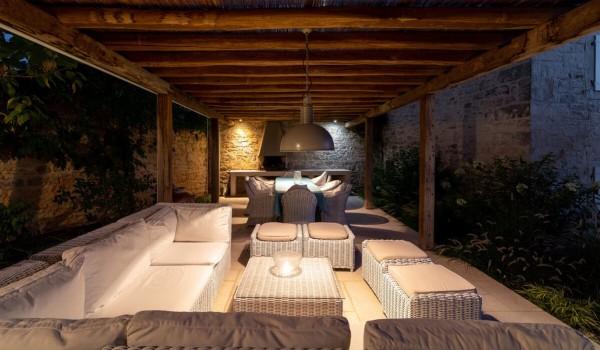 Sitting corner in the roofed part of the fenced terrace of the luxury stone vacation villa Deluxe Manor Baderna