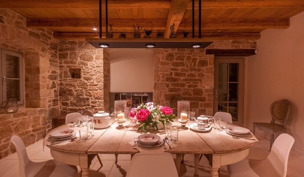 Antique wooden dining table with chairs in the dining room of the family rental villa in Radovani