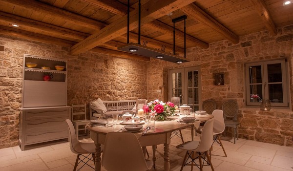 Comfortable, rustically decorated dining room with a dining table and chairs, a wooden bench and a dish rack