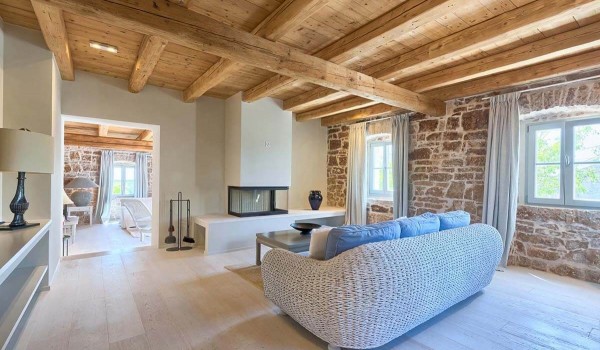 Airy living room with a comfortable sofa and an indoor fireplace in the vacation and rental villa Deluxe Manor Baderna in Istria