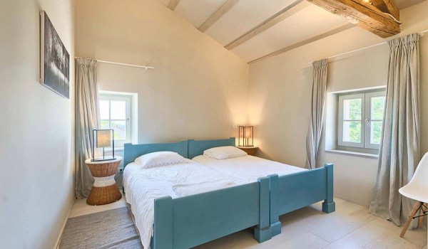Two joined beds in a minimalist bedroom in the attic of the Deluxe Manor Baderna vacation and rental villa in Radovani
