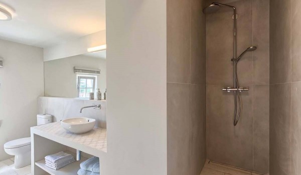 Walk-in shower, toilet and sink with mirror in the modern bathroom of the family villa for rent and vacation in Radovani