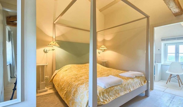 Minimalist bedroom with a double bed and an en suite bathroom inside a luxury villa with pool in Istria