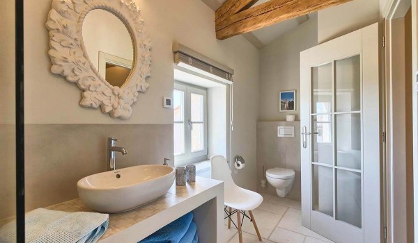 Unique mirror above the sink in the modern en suite bathroom of the stone vacation villa Deluxe Manor Baderna