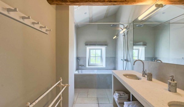 Comfortable modern bathroom with two sinks and a bathtub in a luxury stone villa for rent in Istria