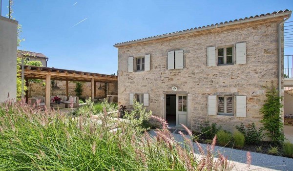 The landscaped yard of the family villa Deluxe Manor Baderna with pool and the entrance to the guest house