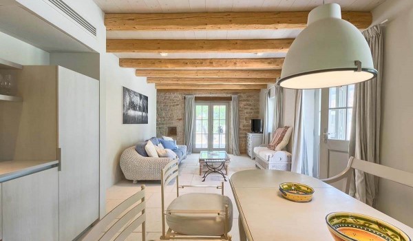 Interior of the charmingly decorated living area with kitchen and living room with couch and TV