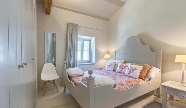 Wooden rustic double bed in a charmingly decorated bedroom with an en suite bathroom in the luxury villa Deluxe Manor Baderna in Radovani