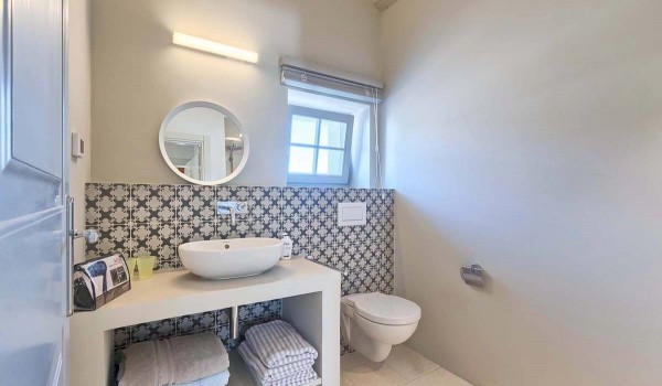 Sink with a mirror and a toilet in the modern bathroom of a vacation rental villa in Radovani