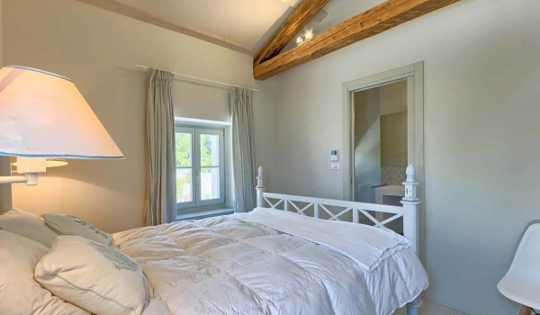Comfortable double bed in the minimalist bedroom of the luxury villa Deluxe Manor Baderna in Istria