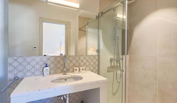 Sink with a mirror and a walk-in shower in a modern en suite bathroom of a luxury villa for rent in Istria