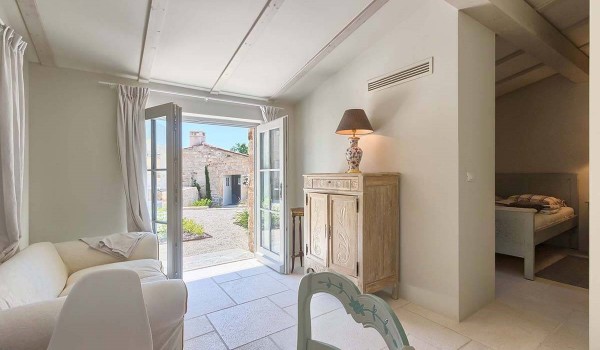 Exit from the living room of the pool house to the landscaped yard full of plants and greenery