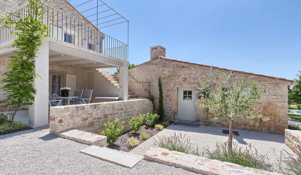 Gravel path and plants in the landscaped yard of the family vacation villa Deluxe Manor Baderna in Radovani