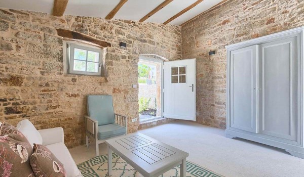 Exit from the comfortable living room with sofa, armchair and wooden wardrobe to the private yard